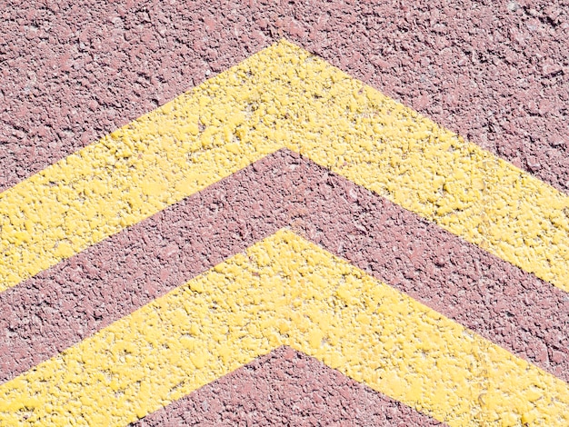 Free photo yellow arrows on asphalt