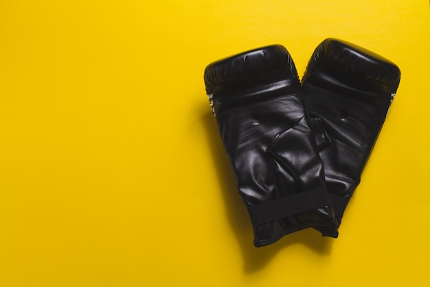 Free photo yellow background with boxing gloves