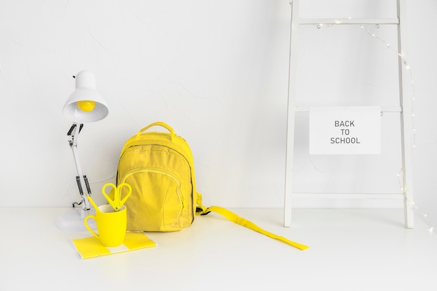 Free Photo yellow backpack in creative teenage workspace