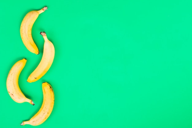 Free photo yellow bananas on green background