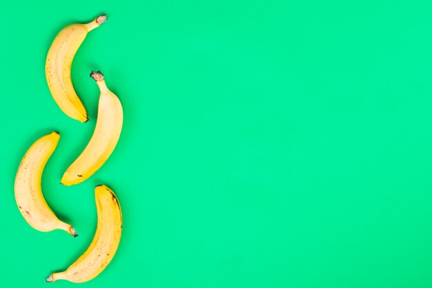 Yellow bananas on green background