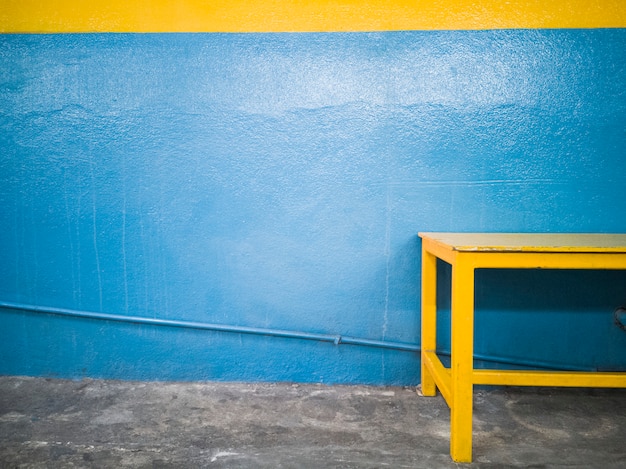 Yellow bench against a blue wall