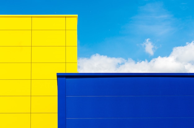 Yellow and a blue building under a blue sky and sunlight during the daytime