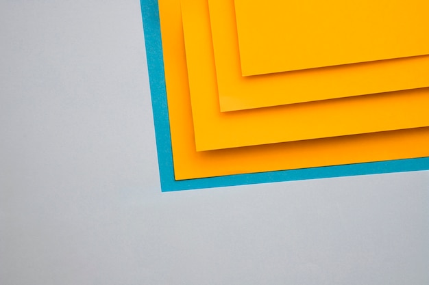 Free photo yellow and blue craftpapers on grey background