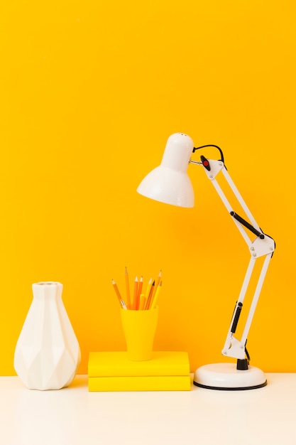 Yellow books and desk lamp front view