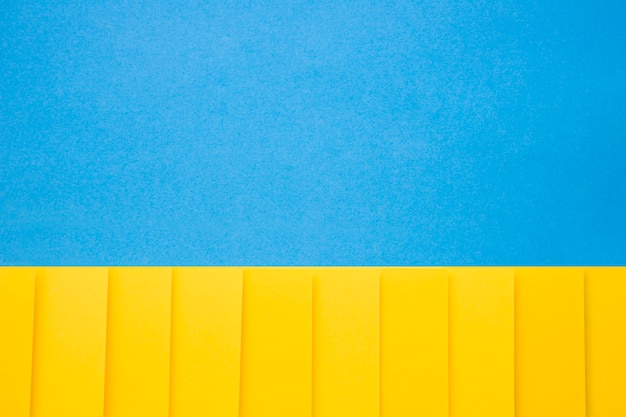 Yellow cardboard papers in a row on blue background