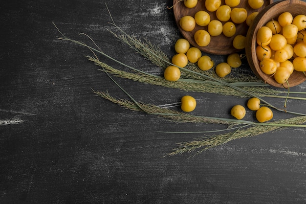 Yellow cherres in wooden or pottery dishes