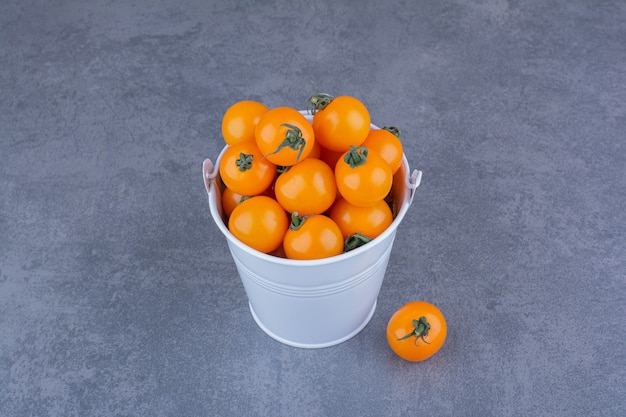 Yellow cherry tomatoes isolated on blue surface