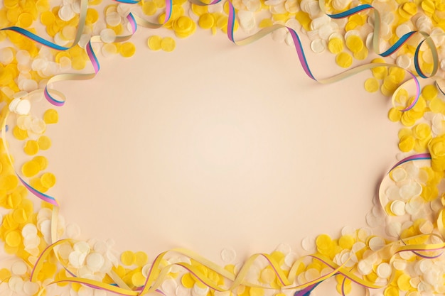 Yellow confetti and ribbons copy space top view