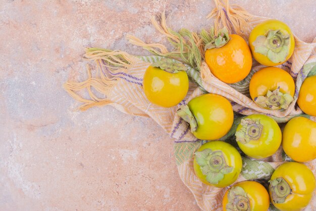 Yellow date plums isolated on a pink surface