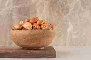 Free photo yellow dry dates isolated on a wooden platter.