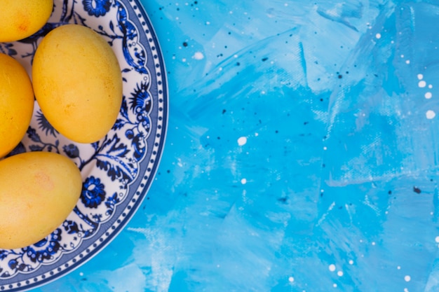 Yellow Easter eggs on plate on table