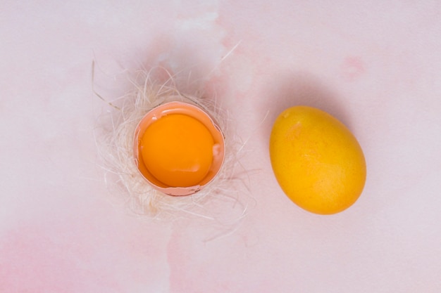 Free photo yellow egg with broken egg in nest