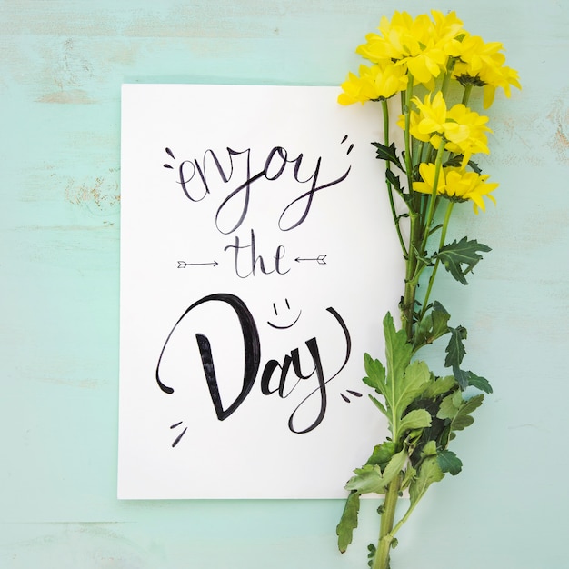 Free Photo yellow flowers near paper with writing