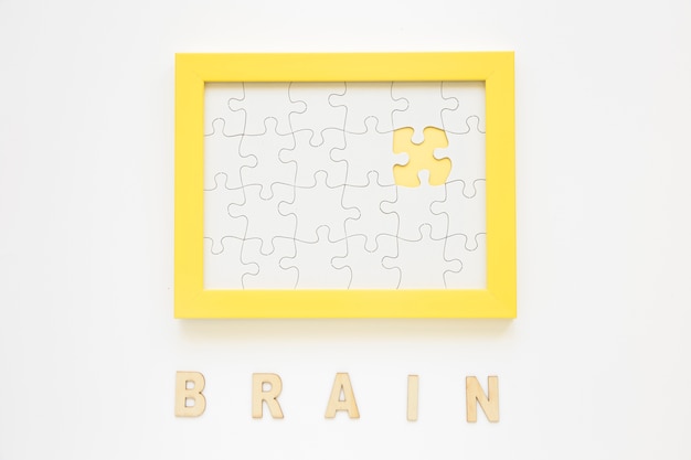 Free photo yellow frame with missing jigsaw piece near brain word