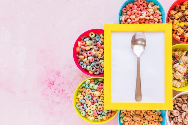 Free Photo yellow frame with spoon on bowls of cereals