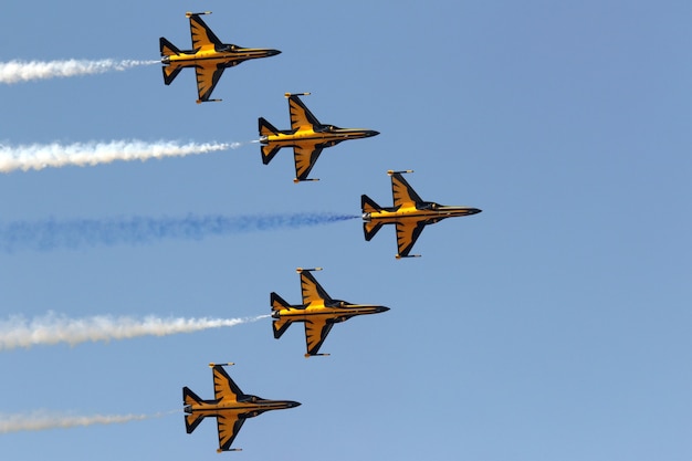 Free Photo yellow jets maneuvering in the sky during an air parade