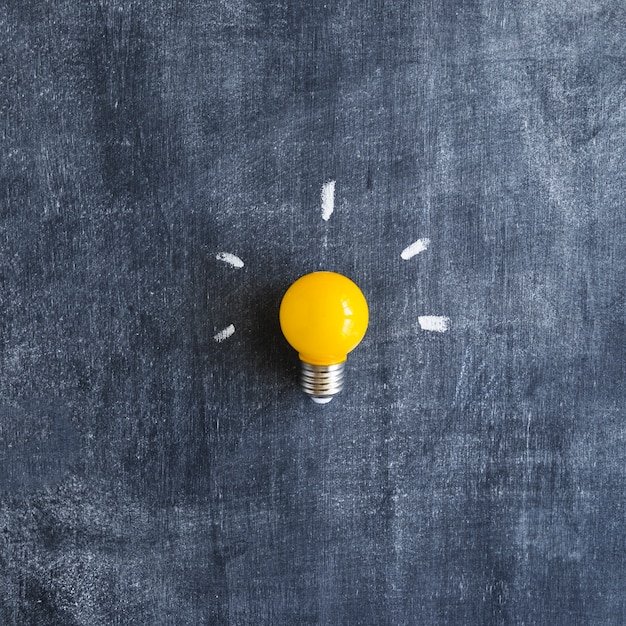 Free photo yellow light bulb on chalkboard