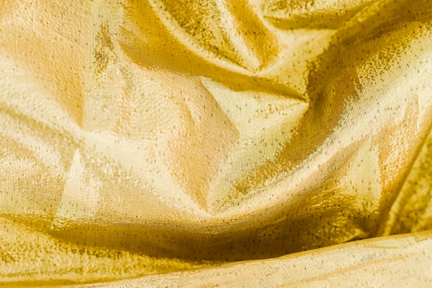 Free photo yellow material surface with twisted waves