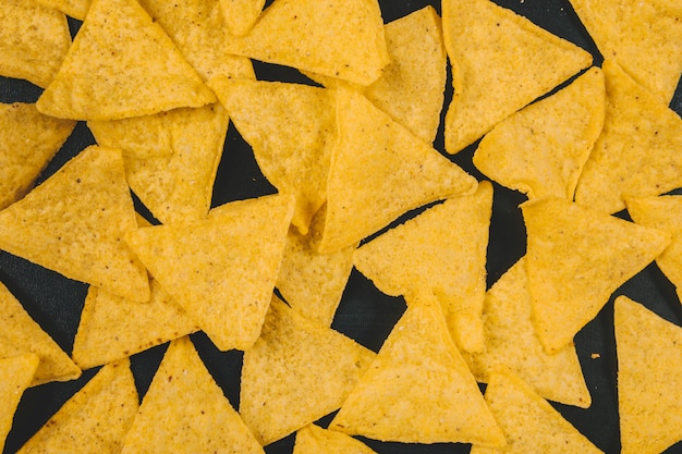 Free photo yellow mexican nachos chips over black background