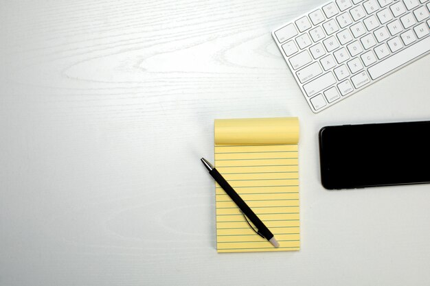 Yellow notepad keyboard and smartphone