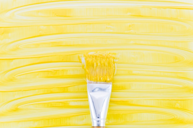 Free photo yellow paint background with brush