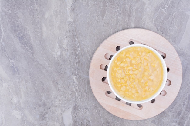 Free photo yellow pea beans soup in a white plate on the wooden board