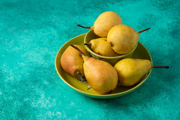 Yellow pears in a green plate. 