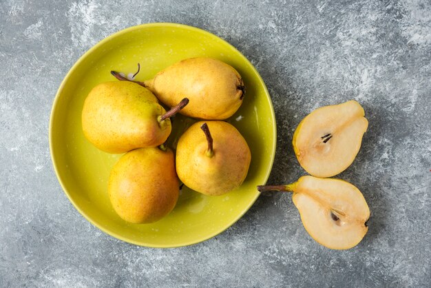 Yellow pears in a green plate.