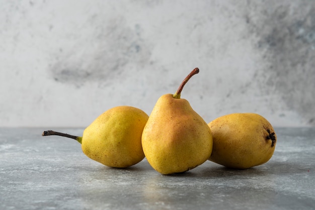 Free photo yellow pears in the stock on concrete table.