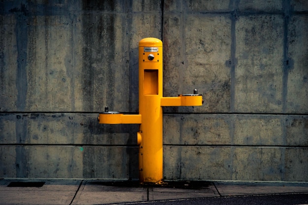 Free Photo yellow pedestal outdoor post against the wall