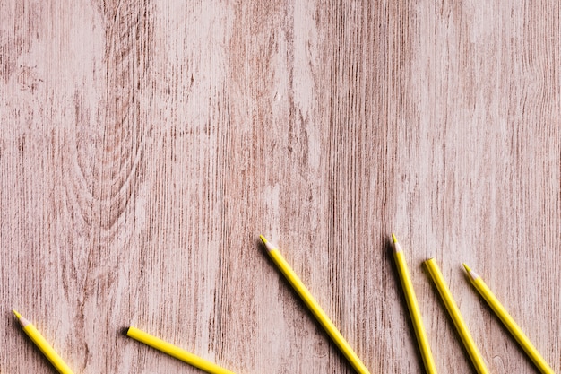 Yellow pencils on wooden surface