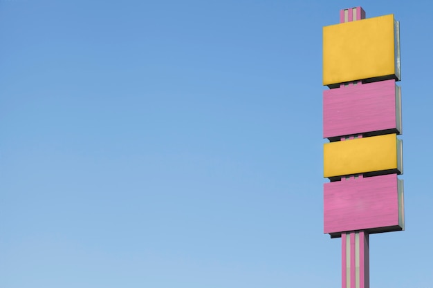 Free photo yellow and pink billboards against blue sky