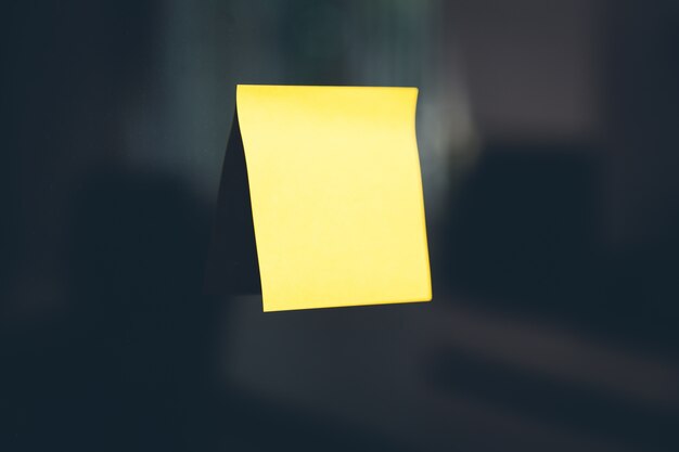 Yellow post-it stuck on a black wall