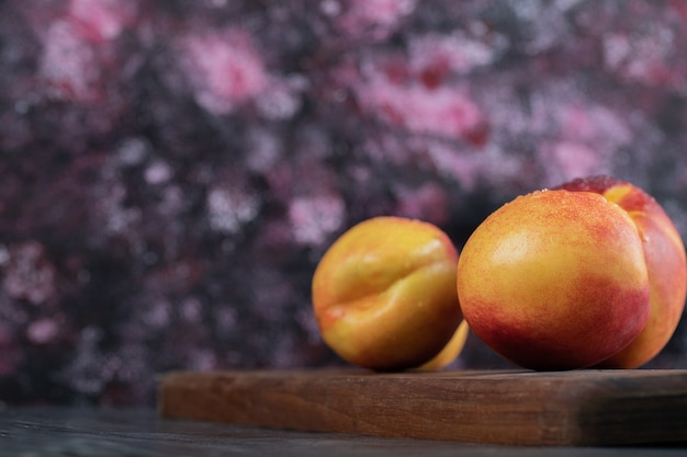 Free photo yellow and red peaches isolated on a wooden platter