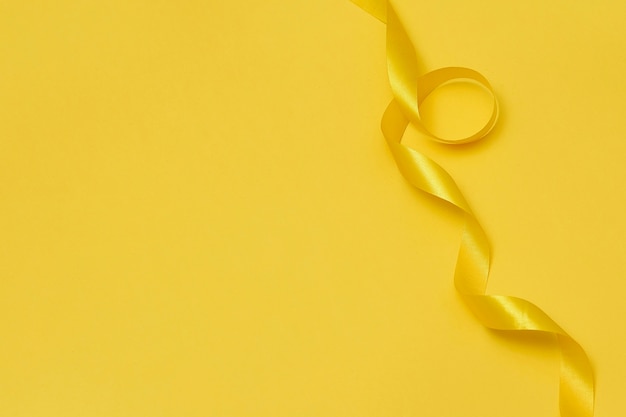 Free photo yellow ribbon on yellowish background