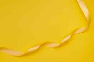 Free photo yellow ribbon on yellowish background