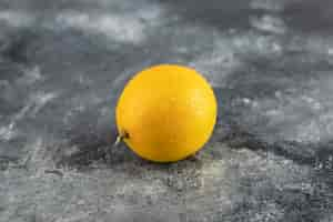 Free photo an yellow ripe lemon on a marble surface.