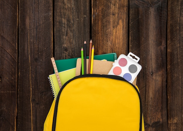 Free photo yellow rucksack with school supplies