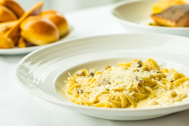 Yellow Spaghetti carbonara with white cream sauce in plate on table - italian food style