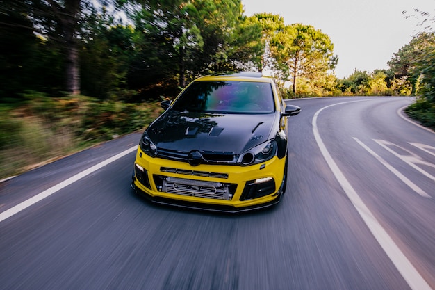 Yellow sport car with black autotuning. High speed drive.