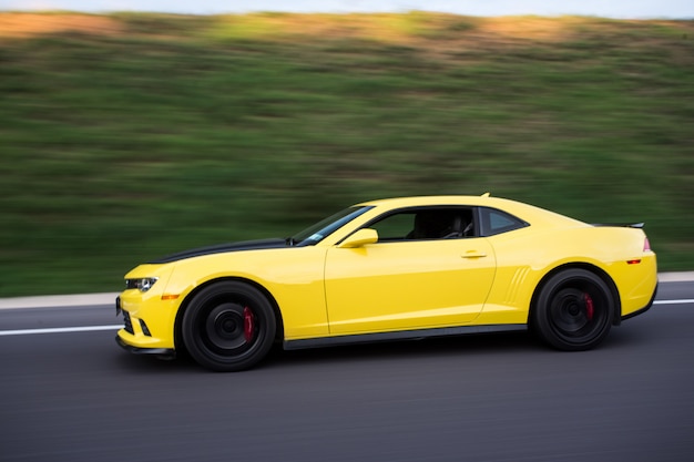 Free photo yellow sport sedan on the road, side view.