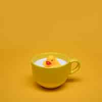 Free photo yellow still life of bath duck in cup of milk