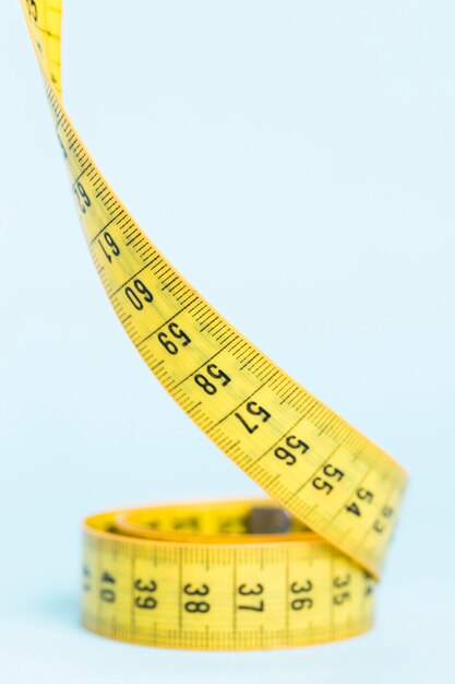 Yellow tape measure on blue background