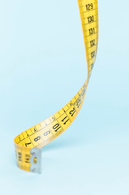 Yellow tape measure on blue background