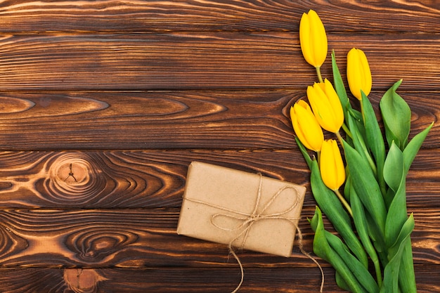 Yellow tulip flowers with gift on table