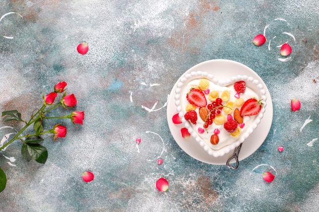 Free photo yogurt with corn flakes and berries in a heart-shaped bowl.