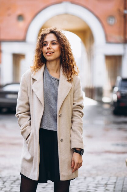 Youn woman with curly hair outside the street