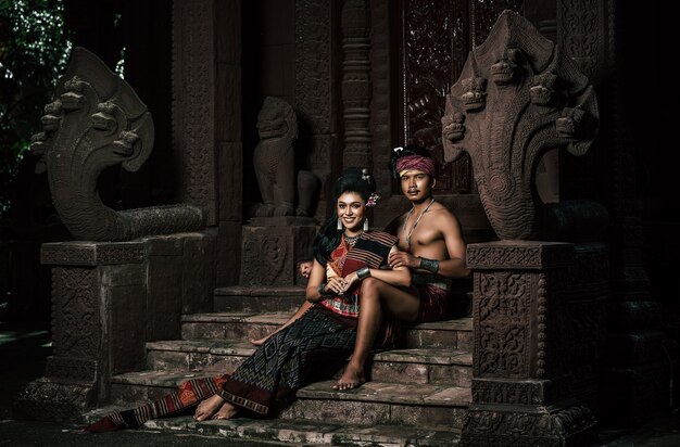 Free photo young actor and actress wearing beautiful ancient costumes, in ancient monuments, dramatic style. perform on legend love popular story, thai isan folktale called 