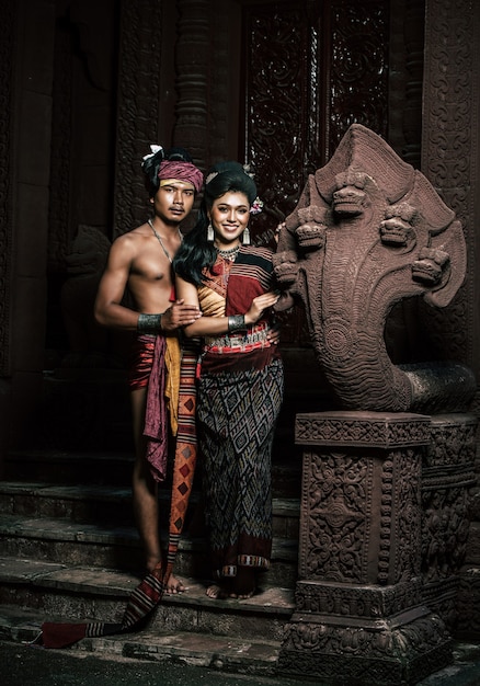 Young Actor and Actress wearing beautiful ancient costumes, in ancient monuments, dramatic style. Perform on legend love popular story, Thai Isan folktale called "Phadaeng and Nang-ai" in acient site